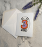 Hand stitched age three birthday card featuring a colourful cross stitch