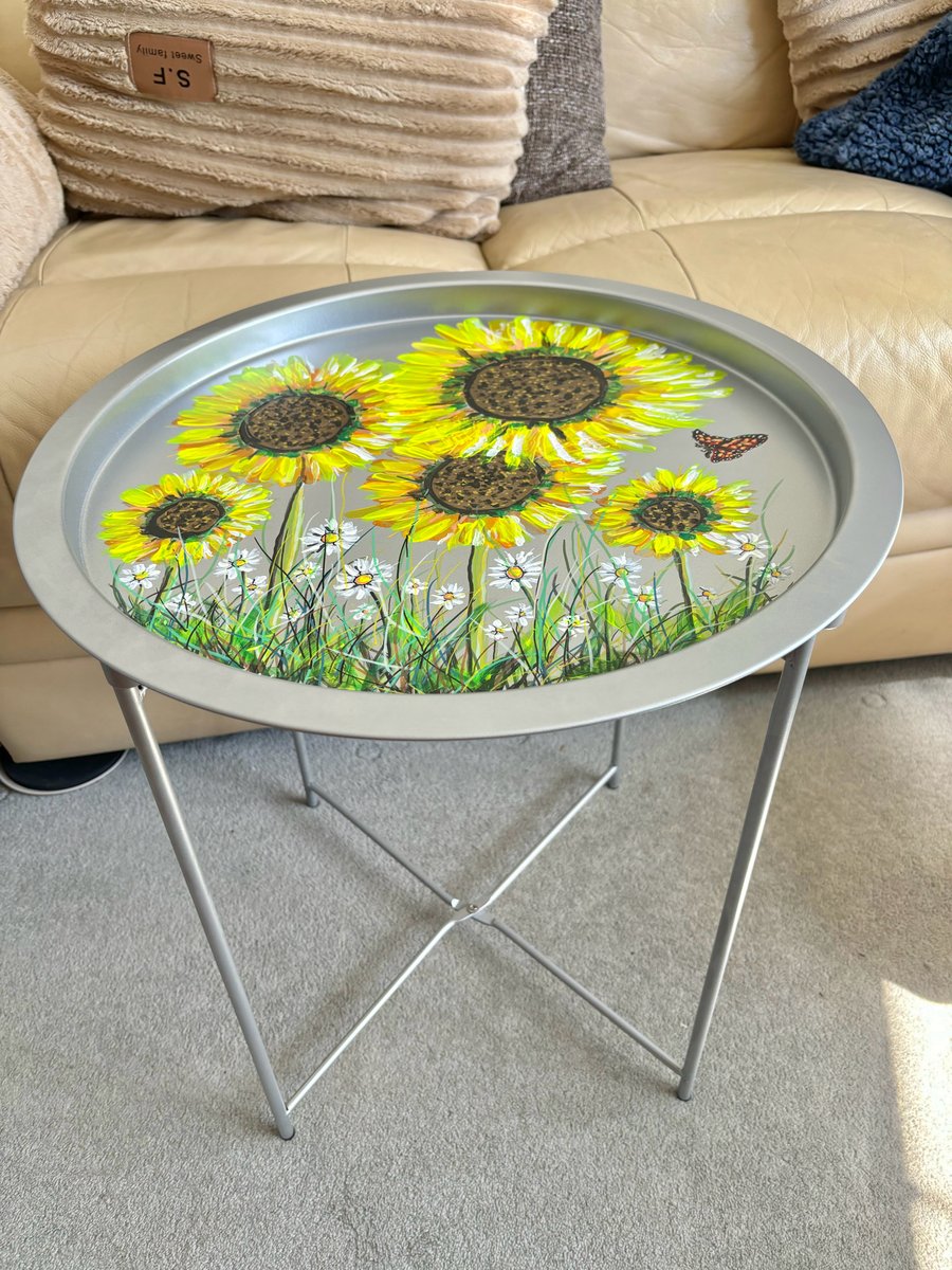 A hand painted and sealed round folding metal table by Andrew Jenkins 