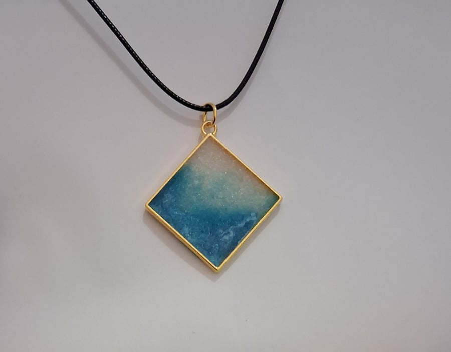 Handmade resin blue and white shimmer pendant on  black waxed cord