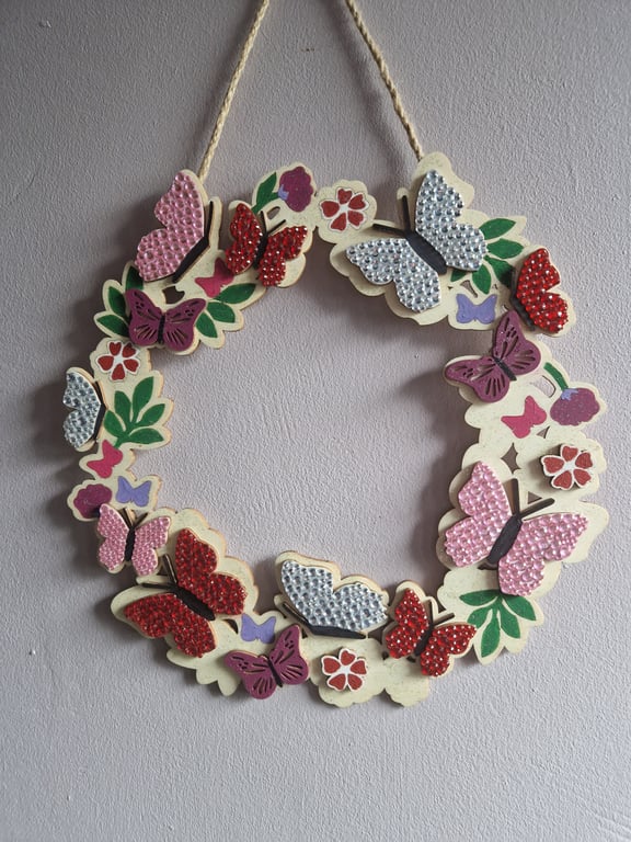 Wooden wreath with flowers and butterflies. 