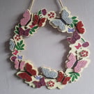 Wooden wreath with flowers and butterflies. 