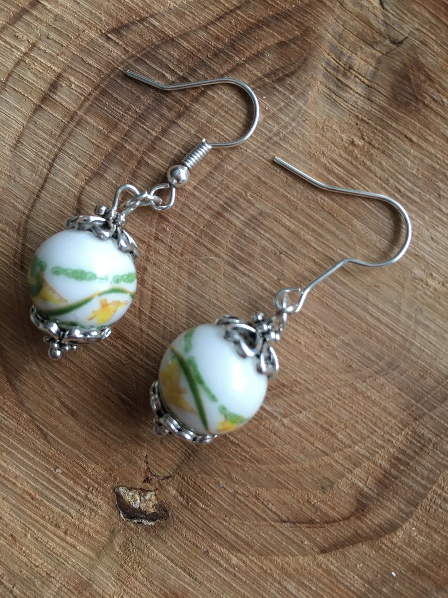 Yellow and green oriental design on a white painted ceramic bead earrings.