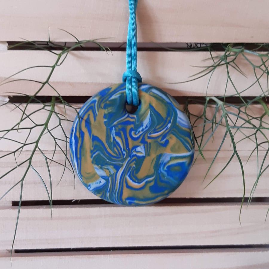 Round pendant in a turquoise, yellow and white polymer clay mix