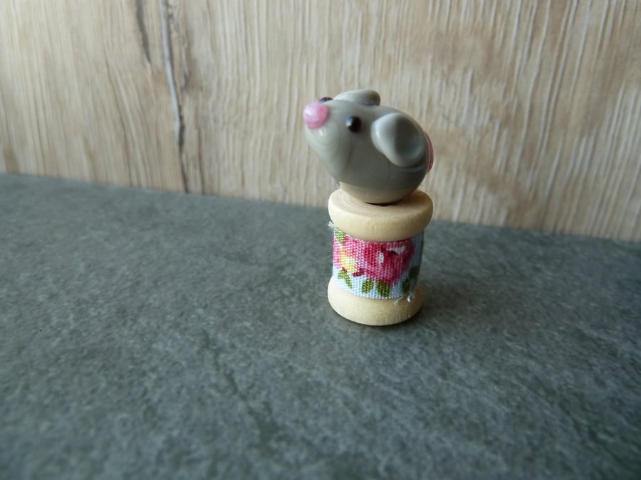 glass mouse on wooden spool