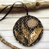 Up-cycled embroidered gold and black flower decoration. 