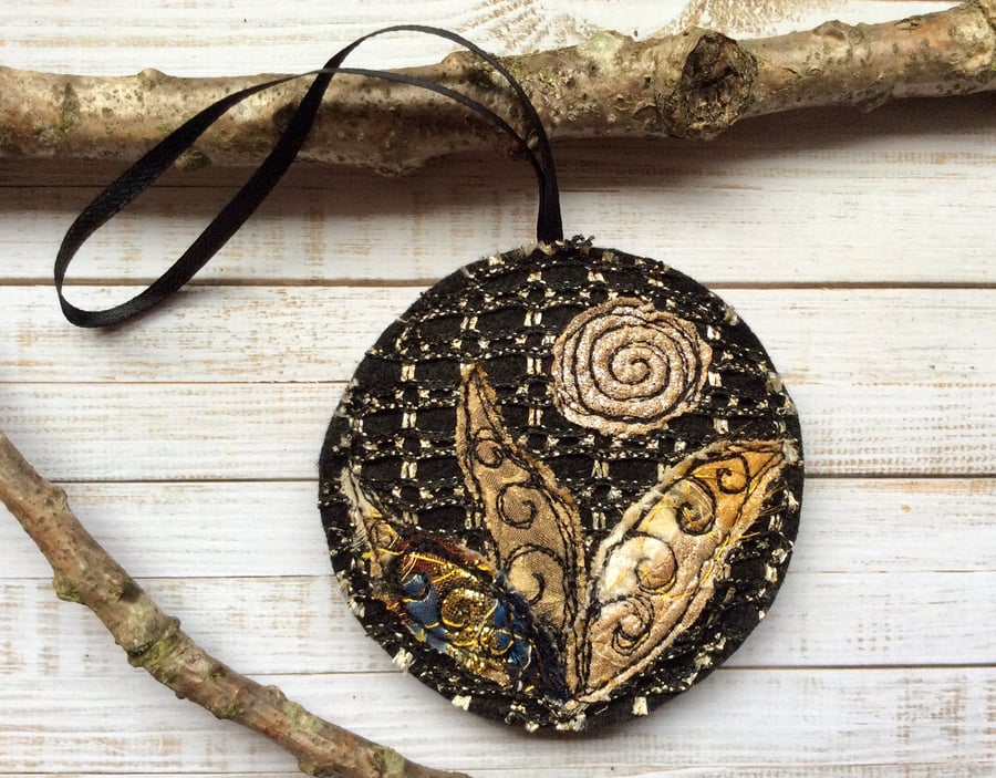 Up-cycled embroidered gold and black flower decoration. 