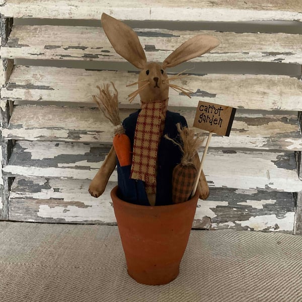 A charming primitive handmade rabbit in a rustic Tom Tom pot