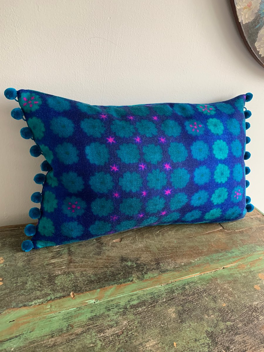 Purple and teal vintage fabric cushion cover with pompoms