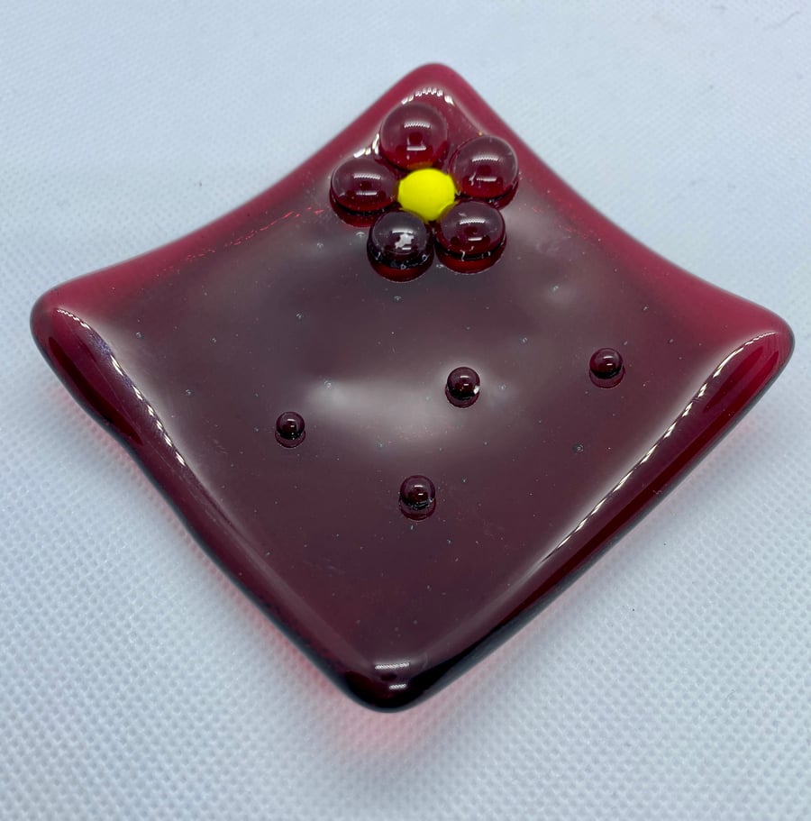 Fused cranberry coloured glass trinket dish with flower decoration