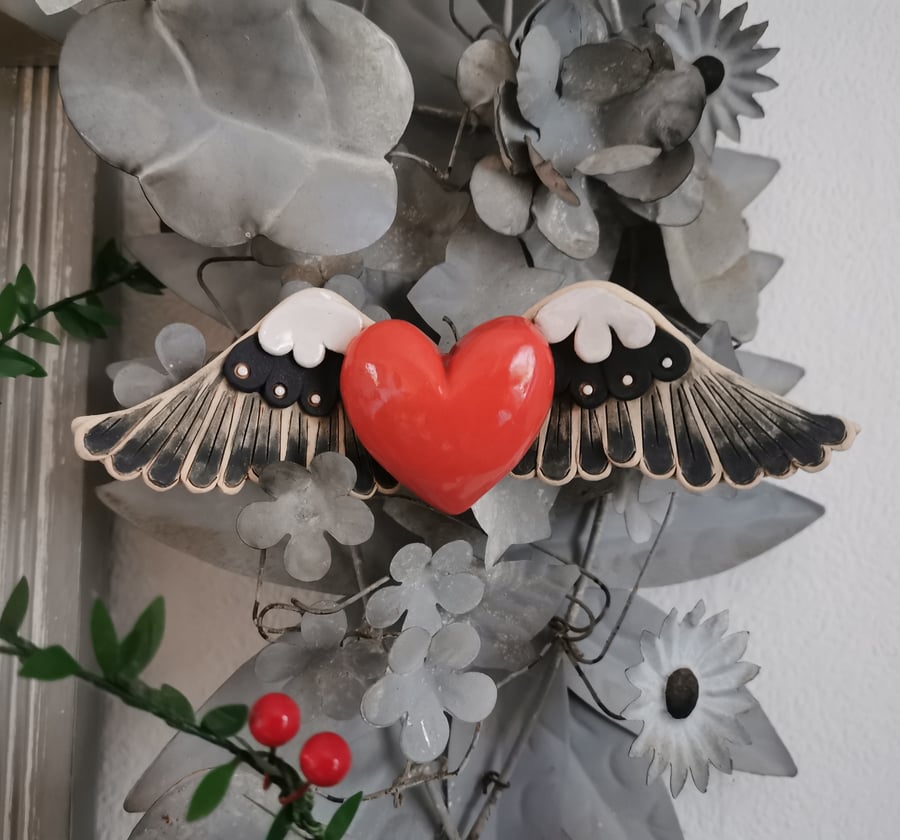 Ceramic winged heart wall art with coral pink glazed heart and monochromes