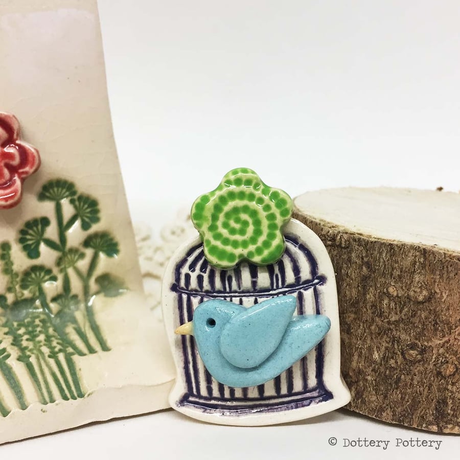 Little ceramic bird cage brooch with flower. Pottery jewellery