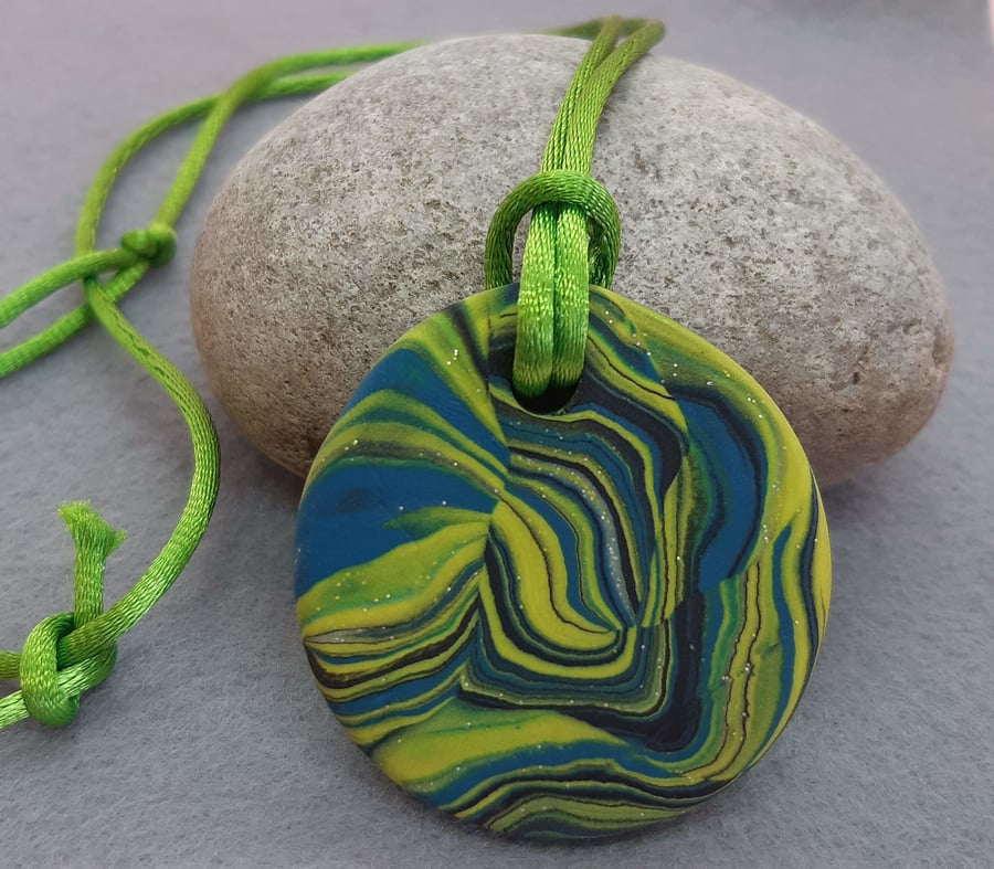 Brightly coloured round polymer clay pendant