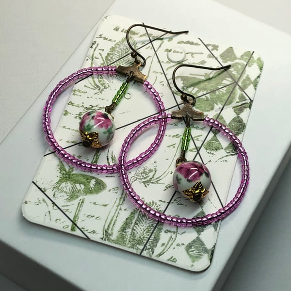 Pink glass hoop earrings with floral porcelain beads
