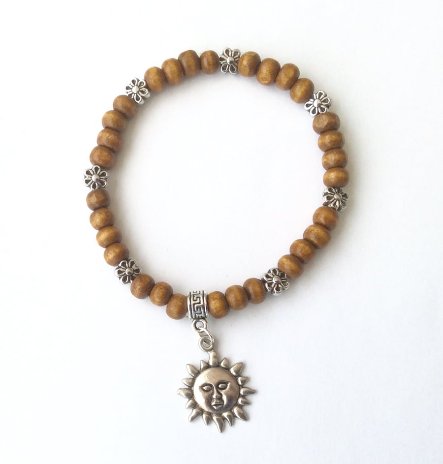 Brown wooden bracelet with Tibetan silver flower spacer beads and a sun charm