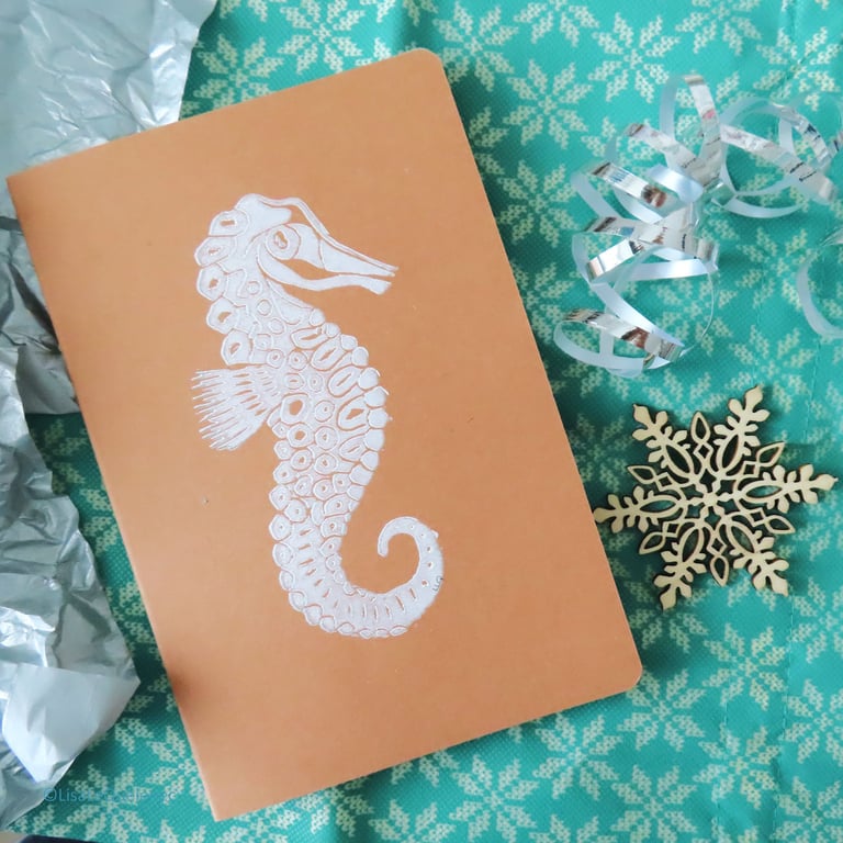 Seahorse motif hand printed lino A5 notebook in white ink on a brown kraft cover