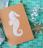 Seahorse motif hand printed lino A5 notebook in white ink on a brown kraft cover