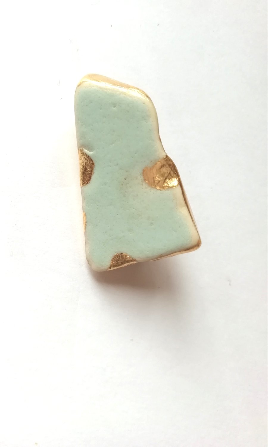 Blue green pottery brooch. 