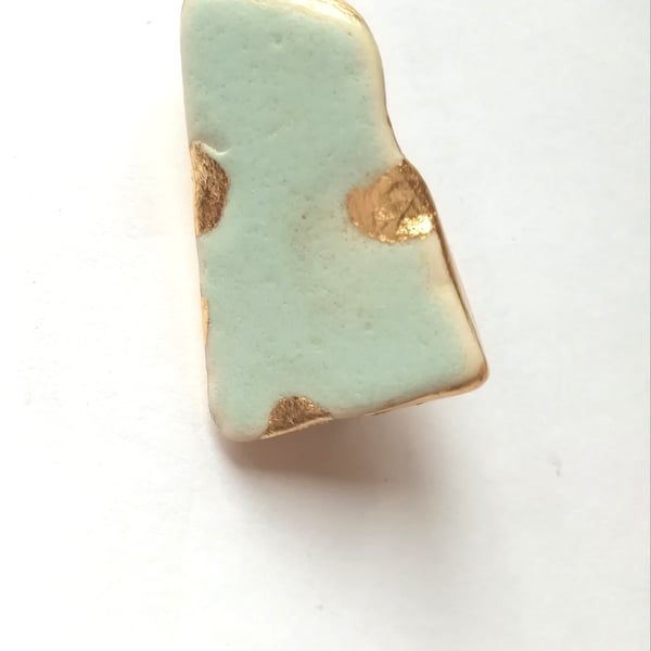 Blue green pottery brooch. 