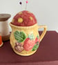 Needle felted pin cushion in repurposed jug with strawberry design