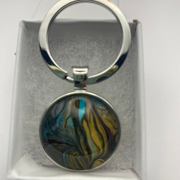 Key ring with acrylic fluid art pendant in silver coloured setting 