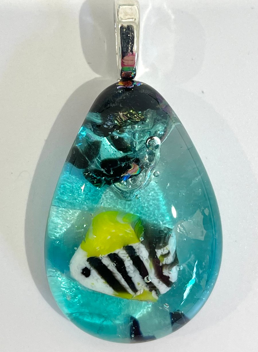 Deep sea inspired kiln formed fused glass pendant with a little fishy