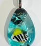 Deep sea inspired kiln formed fused glass pendant with a little fishy