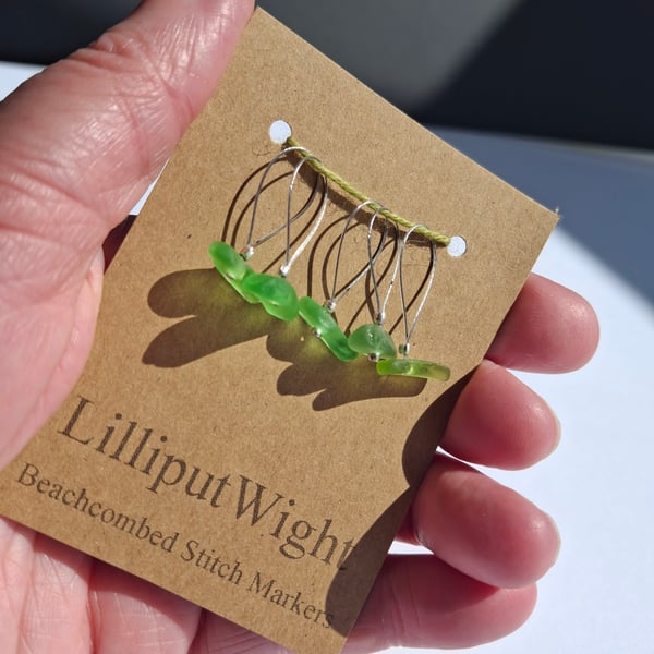 Five sea glass stitch markers in shades of green