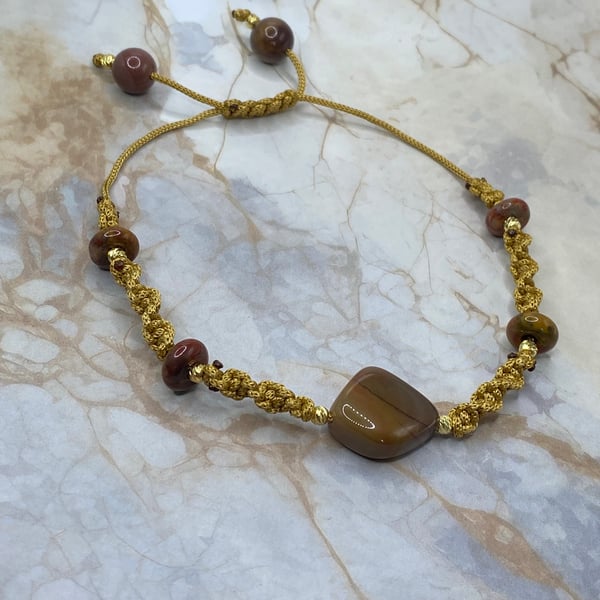 Gold tone macrame cord bracelet with nuggets of mookaite stone