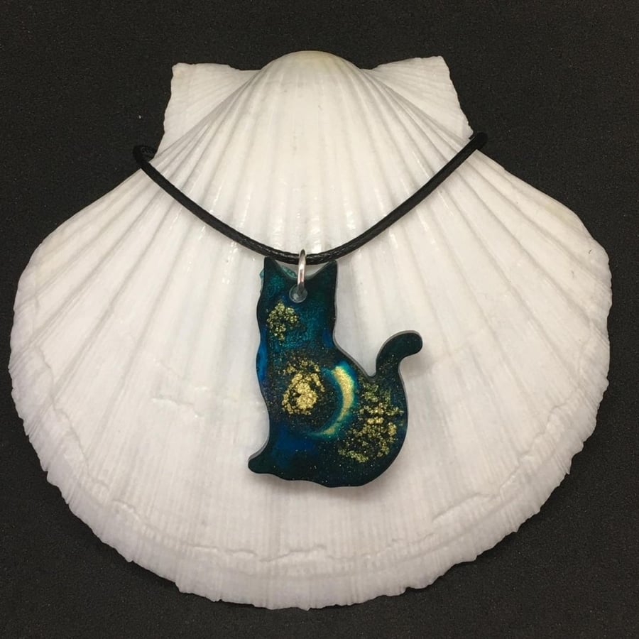 Teal green and gold celestial cat pendant with black cord necklace.