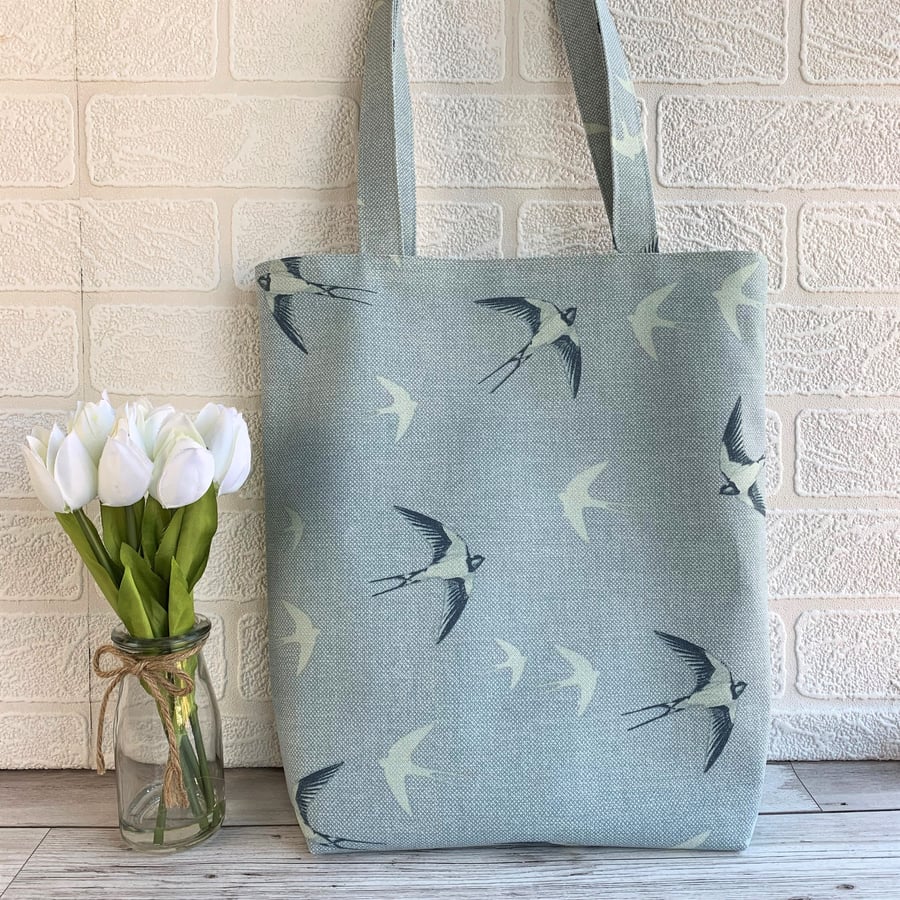 Blue tote bag with swallows in flight print pattern