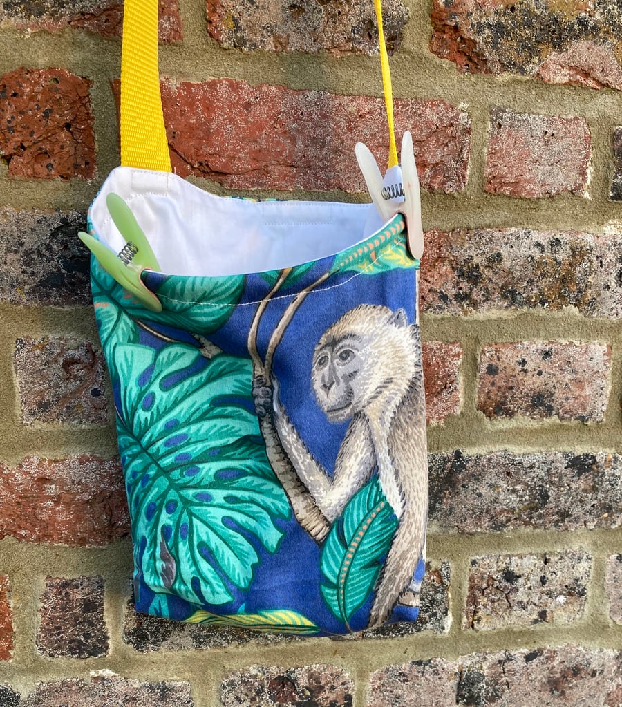 Blue peg bag with yellow shoulder strap. Jungle and monkey print