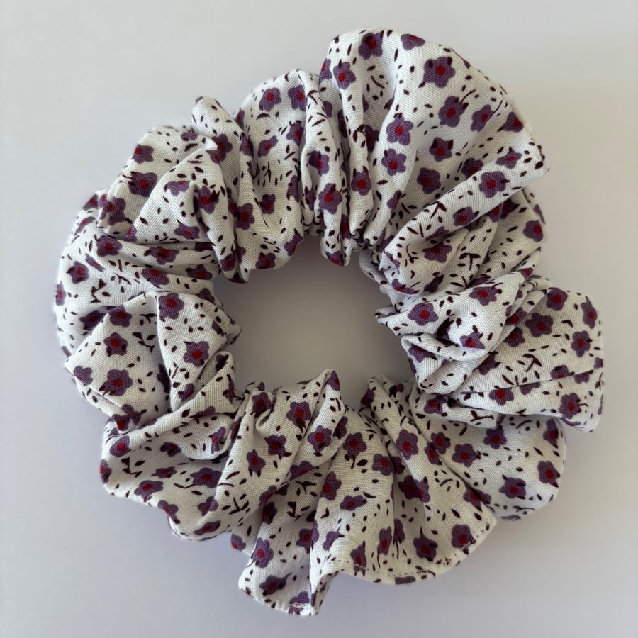 Cotton scrunchie hair accessory in a floral print in white and purple.