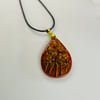 A hand painted and resin layered pendant necklace by Andrew Jenkins 