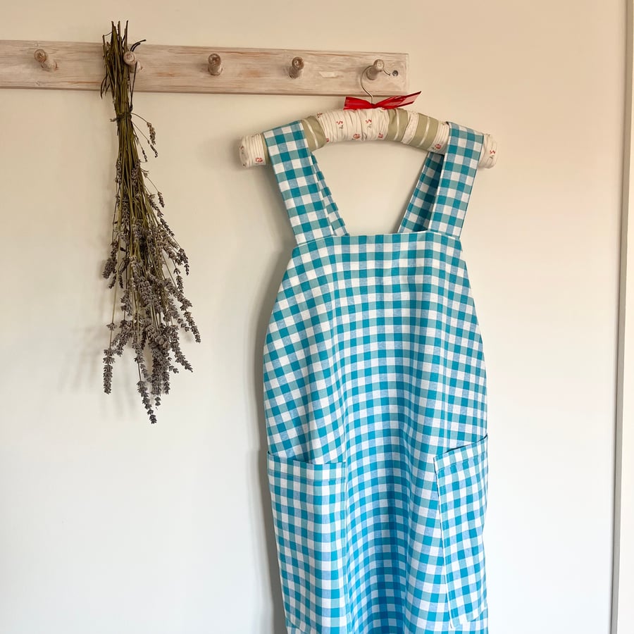 Cross back apron in blue cotton gingham
