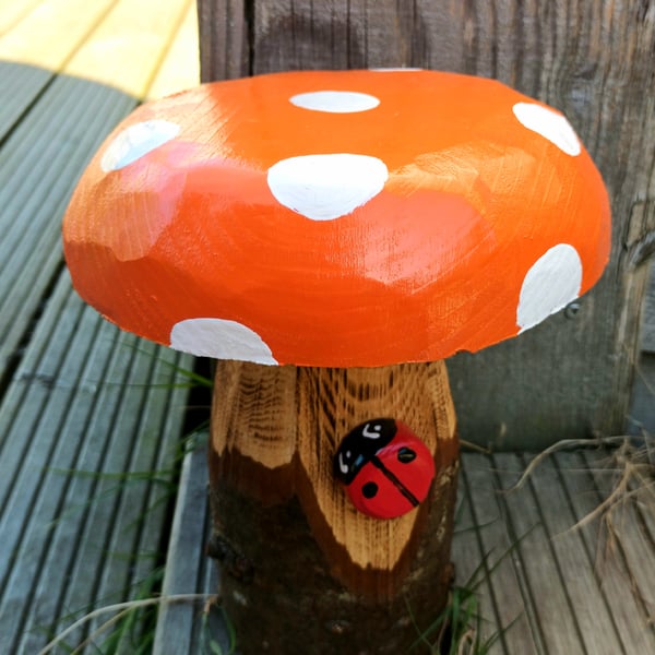 Orange toadstool with ladybird
