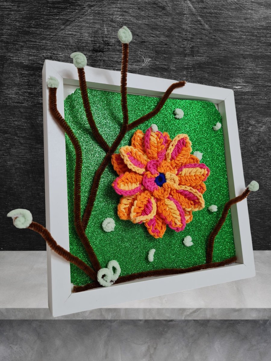 photo frame decorated with crocheted orange flower