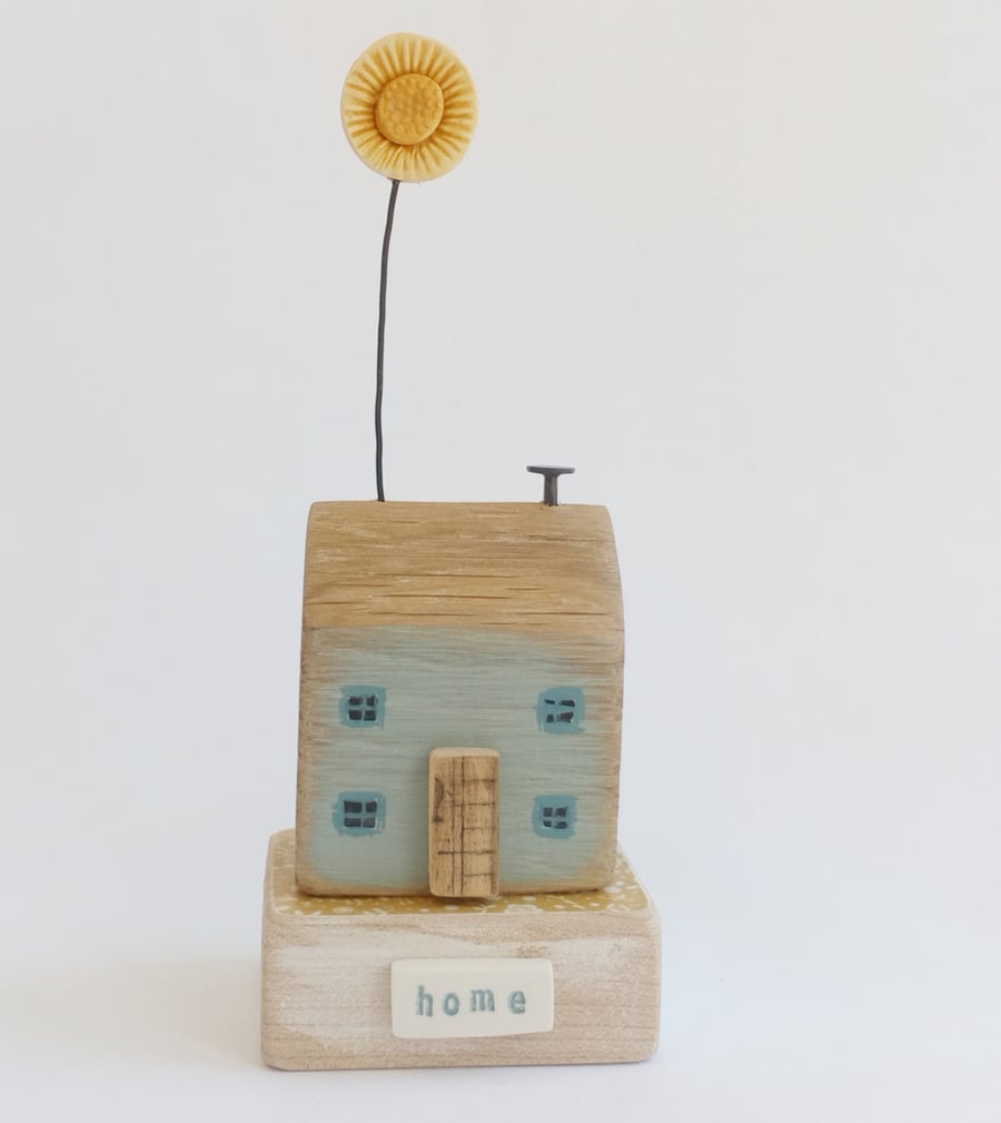 Wooden house with clay sunflower 'home' 