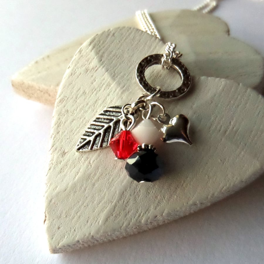 Cluster necklace with leaf and heart charms, and red Swarovski® crystal