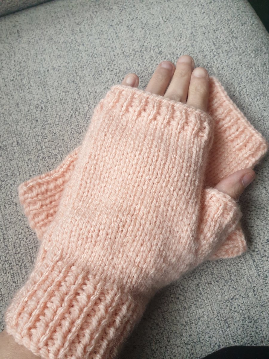 Peach knitted fingerless gloves.