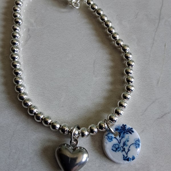 Sterling silver bracelet with charm and stainless steel puffy heart charm