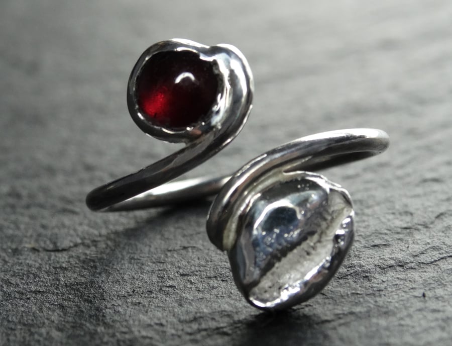 Tristan ring. sterling silver, cast cowry shell and, garnet . Fully adjustable