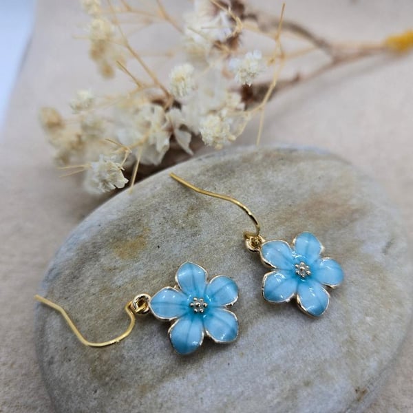 Handmade hypoallergenic gold plated earrings with light blue sakura flower charm