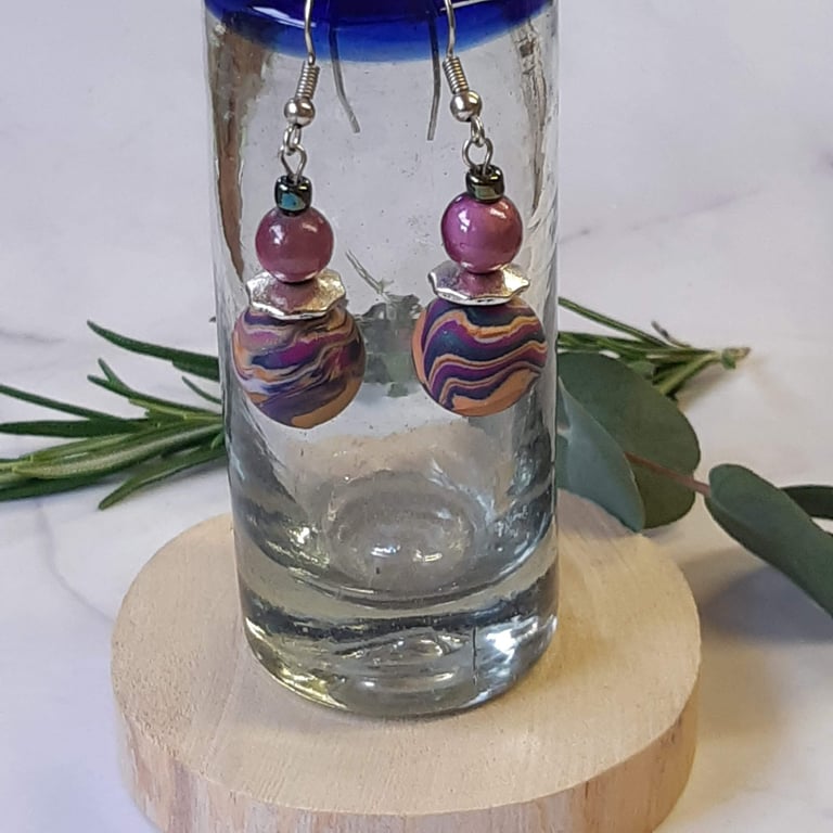 Handmade dangly polymer clay earrings in a colourful swirl design
