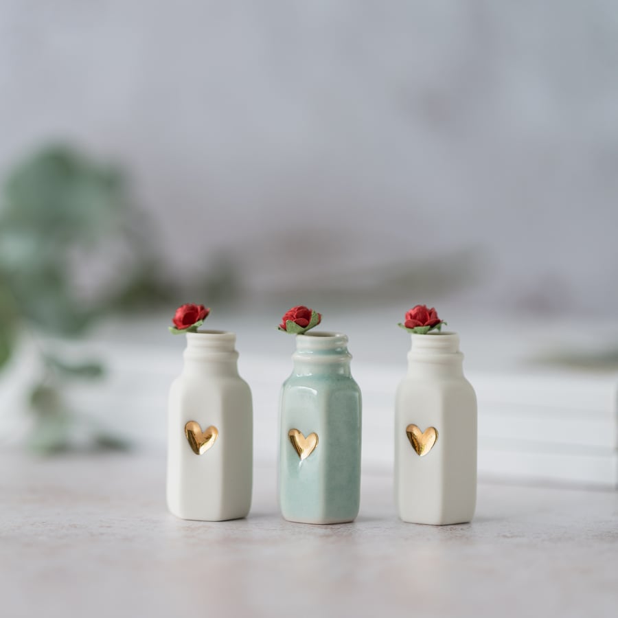 Small Flat Sided Bottle with a Gold Embossed Heart and A Red Paper Rose