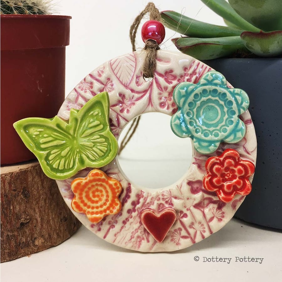 Small ceramic floral wreath decoration with flowers and butterfly