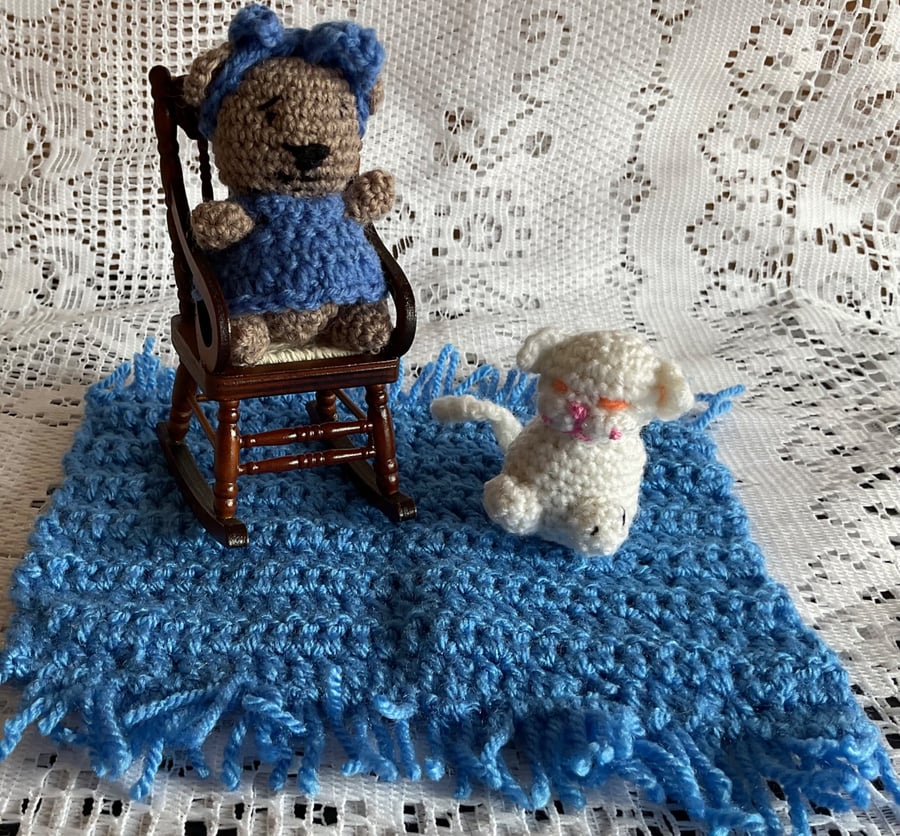Teddy sitting in a rocking chair on a mat with her cat