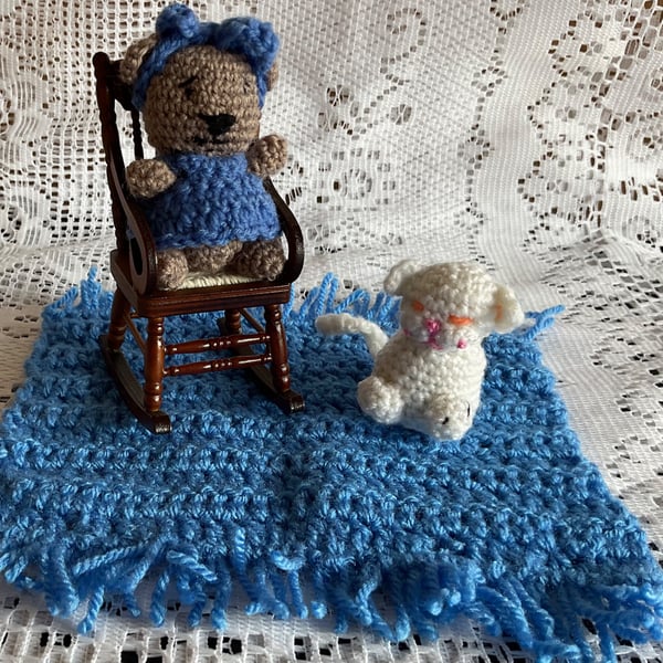 Teddy sitting in a rocking chair on a mat with her cat