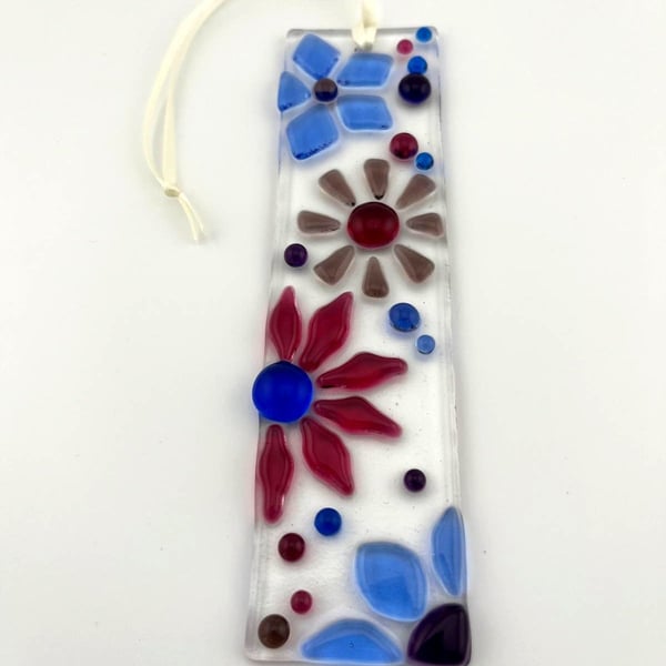 Fused glass floral suncatcher in blues and pinks.