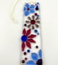 Fused glass floral suncatcher in blues and pinks.