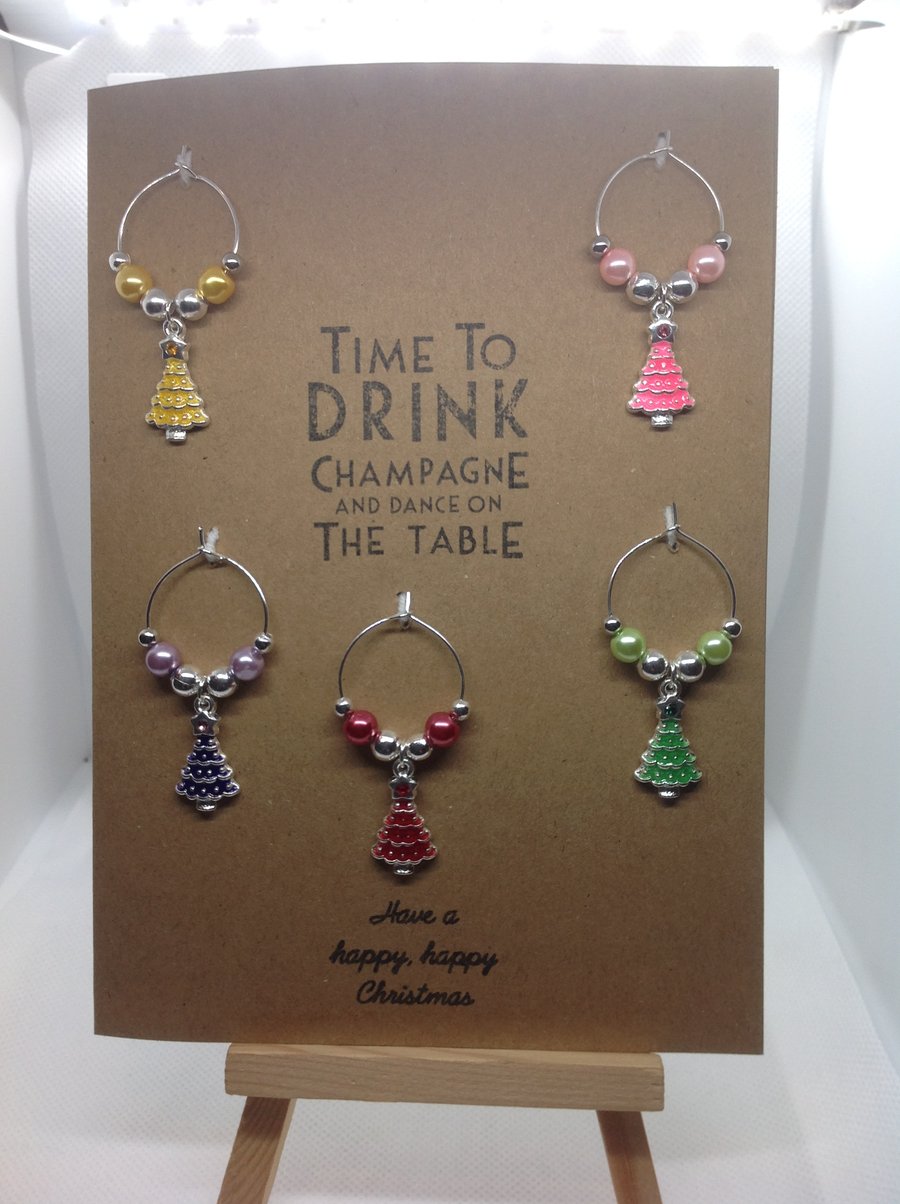 Hand made Christmas themed wine glass charms on a greetings card